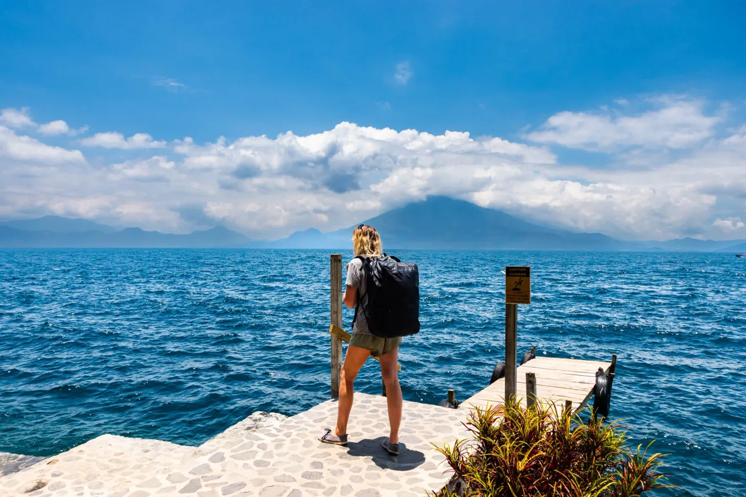 A picture of a woman on Lake Atitlán with a backpack (travel essentials for women)